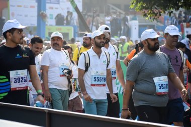 Yeni Delhi, Hindistan - 20 Ekim 2024 - Bitmek üzere olan maraton katılımcılarının bitiş çizgisini geçmek üzere olan Delhi Yarı Maratonu 2024