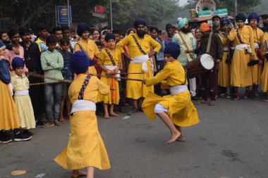 Delhi, Hindistan, 17 Kasım 2024 - Doğu Delhi bölgesinde Guru Nanak Dev, Nagar Kirtan 'ın doğum günü dolayısıyla geleneksel Nagar Kirtan, geleneksel Nagar geçit töreninde Sihler gatka ve dövüş sanatlarını sergiliyor