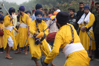Delhi, Hindistan, 17 Kasım 2024 - Doğu Delhi bölgesinde Guru Nanak Dev, Nagar Kirtan 'ın doğum günü dolayısıyla geleneksel Nagar Kirtan, geleneksel Nagar geçit töreninde Sihler gatka ve dövüş sanatlarını sergiliyor