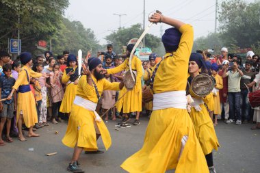 Delhi, Hindistan, 17 Kasım 2024 - Doğu Delhi bölgesinde Guru Nanak Dev, Nagar Kirtan 'ın doğum günü dolayısıyla geleneksel Nagar Kirtan, geleneksel Nagar geçit töreninde Sihler gatka ve dövüş sanatlarını sergiliyor
