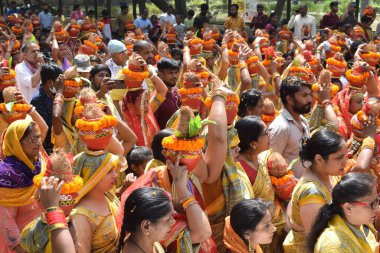 New Delhi, India July 25 2024 - Women with Kalash on head during Jagannath Temple Mangal Kalash Yatra, Indian Hindu devotees carry earthen pots containing sacred water with a coconut on top clipart