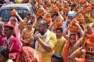 New Delhi, India July 25 2024 - Women with Kalash on head during Jagannath Temple Mangal Kalash Yatra, Indian Hindu devotees carry earthen pots containing sacred water with a coconut on top clipart