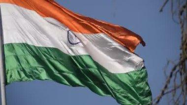 India flag flying high at Connaught Place with pride in blue sky, India flag fluttering, Indian Flag on Independence Day and Republic Day of India, tilt up shot, Waving Indian flag, Har Ghar Tiranga