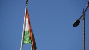 India flag flying high at Connaught Place with pride in blue sky, India flag fluttering, Indian Flag on Independence Day and Republic Day of India, tilt up shot, Waving Indian flag, Har Ghar Tiranga