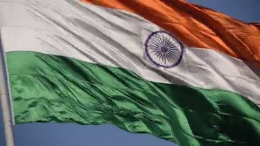 India flag flying high at Connaught Place with pride in blue sky, India flag fluttering, Indian Flag on Independence Day and Republic Day of India, tilt up shot, Waving Indian flag, Har Ghar Tiranga
