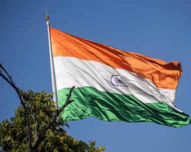 India flag flying high at Connaught Place with pride in blue sky, India flag fluttering, Indian Flag on Independence Day and Republic Day of India, tilt up shot, Waving Indian flag, Har Ghar Tiranga