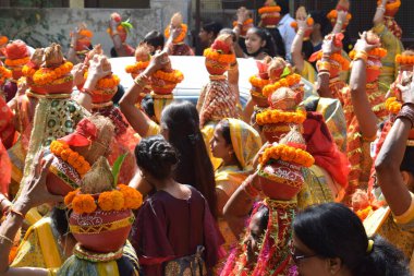 Yeni Delhi, Hindistan 25 Temmuz 2024 - Jagannath Tapınağı sırasında Kalaşlı kadınlar Mangal Kalash Yatra, Hintli Hintli dindarlar üzerinde hindistancevizi olan toprak kapları taşıyorlar