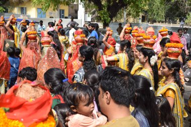 New Delhi, India July 25 2024 - Women with Kalash on head during Jagannath Temple Mangal Kalash Yatra, Indian Hindu devotees carry earthen pots containing sacred water with a coconut on top clipart