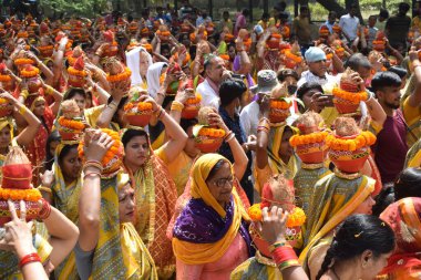 Yeni Delhi, Hindistan 25 Temmuz 2024 - Jagannath Tapınağı sırasında Kalaşlı kadınlar Mangal Kalash Yatra, Hintli Hintli dindarlar üzerinde hindistancevizi olan toprak kapları taşıyorlar