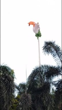 India flag flying high at Connaught Place with pride in blue sky, India flag fluttering, Indian Flag on Independence Day and Republic Day of India, tilt up shot, Waving Indian flag, Har Ghar Tiranga