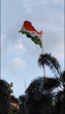 India flag flying high at Connaught Place with pride in blue sky, India flag fluttering, Indian Flag on Independence Day and Republic Day of India, tilt up shot, Waving Indian flag, Har Ghar Tiranga