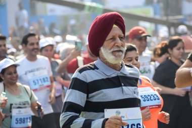 Yeni Delhi, Hindistan - 20 Ekim 2024 - Bitmek üzere olan maraton katılımcılarının bitiş çizgisini geçmek üzere olan Delhi Yarı Maratonu 2024