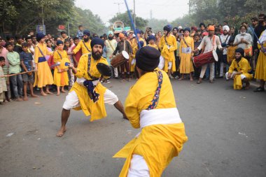 Delhi, Hindistan, 17 Kasım 2024 - Doğu Delhi bölgesinde Guru Nanak Dev, Nagar Kirtan 'ın doğum günü dolayısıyla geleneksel Nagar Kirtan, geleneksel Nagar geçit töreninde Sihler gatka ve dövüş sanatlarını sergiliyor