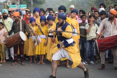 Delhi, Hindistan, 17 Kasım 2024 - Doğu Delhi bölgesinde Guru Nanak Dev, Nagar Kirtan 'ın doğum günü dolayısıyla geleneksel Nagar Kirtan, geleneksel Nagar geçit töreninde Sihler gatka ve dövüş sanatlarını sergiliyor