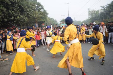 Delhi, Hindistan, 17 Kasım 2024 - Doğu Delhi bölgesinde Guru Nanak Dev, Nagar Kirtan 'ın doğum günü dolayısıyla geleneksel Nagar Kirtan, geleneksel Nagar geçit töreninde Sihler gatka ve dövüş sanatlarını sergiliyor