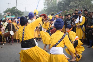 Delhi, Hindistan, 17 Kasım 2024 - Doğu Delhi bölgesinde Guru Nanak Dev, Nagar Kirtan 'ın doğum günü dolayısıyla geleneksel Nagar Kirtan, geleneksel Nagar geçit töreninde Sihler gatka ve dövüş sanatlarını sergiliyor