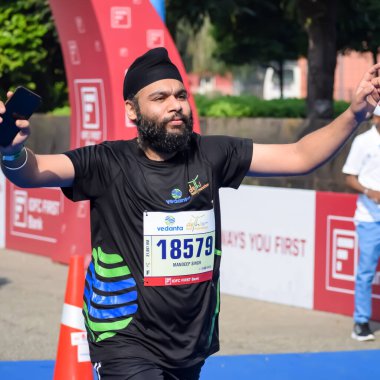 Yeni Delhi, Hindistan - 20 Ekim 2024 - Bitmek üzere olan maraton katılımcılarının bitiş çizgisini geçmek üzere olan Delhi Yarı Maratonu 2024