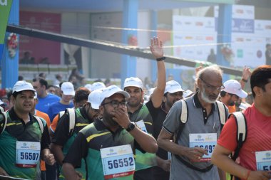 Yeni Delhi, Hindistan - 20 Ekim 2024 - Bitmek üzere olan maraton katılımcılarının bitiş çizgisini geçmek üzere olan Delhi Yarı Maratonu 2024