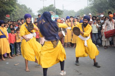 Delhi, Hindistan, 17 Kasım 2024 - Doğu Delhi bölgesinde Guru Nanak Dev, Nagar Kirtan 'ın doğum günü dolayısıyla geleneksel Nagar Kirtan, geleneksel Nagar geçit töreninde Sihler gatka ve dövüş sanatlarını sergiliyor