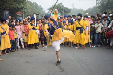 Delhi, Hindistan, 17 Kasım 2024 - Doğu Delhi bölgesinde Guru Nanak Dev, Nagar Kirtan 'ın doğum günü dolayısıyla geleneksel Nagar Kirtan, geleneksel Nagar geçit töreninde Sihler gatka ve dövüş sanatlarını sergiliyor