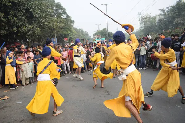 Delhi, Hindistan, 17 Kasım 2024 - Doğu Delhi bölgesinde Guru Nanak Dev, Nagar Kirtan 'ın doğum günü dolayısıyla geleneksel Nagar Kirtan, geleneksel Nagar geçit töreninde Sihler gatka ve dövüş sanatlarını sergiliyor