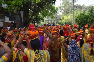 Yeni Delhi, Hindistan 25 Temmuz 2024 - Jagannath Tapınağı sırasında Kalaşlı kadınlar Mangal Kalash Yatra, Hintli Hintli dindarlar üzerinde hindistancevizi olan toprak kapları taşıyorlar