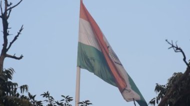 India flag flying high at Connaught Place with pride in blue sky, India flag fluttering, Indian Flag on Independence Day and Republic Day of India, tilt up shot, Waving Indian flag, Har Ghar Tiranga