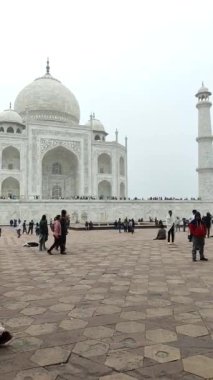 Agra, Uttar Pradesh, Hindistan - 31 Aralık 2024 - Yedi Dünya harikalarından birini ziyaret eden insanlar Taj Mahal. Bulutlu bir günde ünlü Hint İslami mirası, Taj Mahal Yamuna Nehri 'nin güney kıyısında yer alıyor.