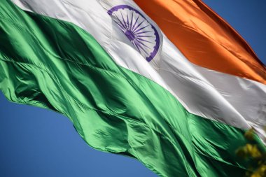 India flag flying high at Connaught Place with pride in blue sky, India flag fluttering, Indian Flag on Independence Day and Republic Day of India, tilt up shot, Waving Indian flag, Har Ghar Tiranga