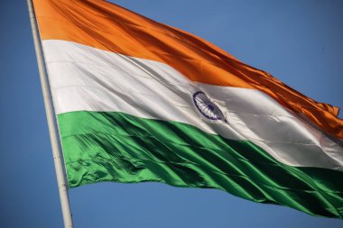 India flag flying high at Connaught Place with pride in blue sky, India flag fluttering, Indian Flag on Independence Day and Republic Day of India, tilt up shot, Waving Indian flag, Har Ghar Tiranga