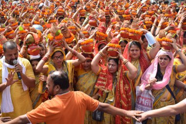 Yeni Delhi, Hindistan 25 Temmuz 2024 - Jagannath Tapınağı sırasında Kalaşlı kadınlar Mangal Kalash Yatra, Hintli Hintli dindarlar üzerinde hindistancevizi olan toprak kapları taşıyorlar