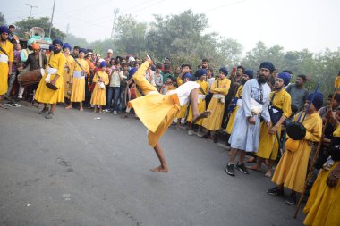 Delhi, Hindistan, 17 Kasım 2024 - Doğu Delhi bölgesinde Guru Nanak Dev, Nagar Kirtan 'ın doğum günü dolayısıyla geleneksel Nagar Kirtan, geleneksel Nagar geçit töreninde Sihler gatka ve dövüş sanatlarını sergiliyor