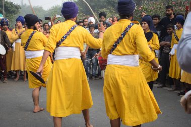 Delhi, Hindistan, 17 Kasım 2024 - Doğu Delhi bölgesinde Guru Nanak Dev, Nagar Kirtan 'ın doğum günü dolayısıyla geleneksel Nagar Kirtan, geleneksel Nagar geçit töreninde Sihler gatka ve dövüş sanatlarını sergiliyor