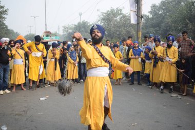 Delhi, Hindistan, 17 Kasım 2024 - Doğu Delhi bölgesinde Guru Nanak Dev, Nagar Kirtan 'ın doğum günü dolayısıyla geleneksel Nagar Kirtan, geleneksel Nagar geçit töreninde Sihler gatka ve dövüş sanatlarını sergiliyor