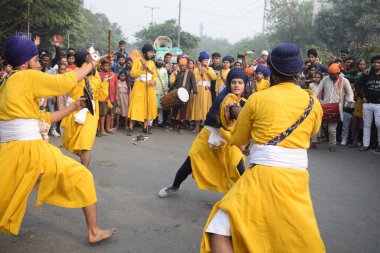 Delhi, Hindistan, 17 Kasım 2024 - Doğu Delhi bölgesinde Guru Nanak Dev, Nagar Kirtan 'ın doğum günü dolayısıyla geleneksel Nagar Kirtan, geleneksel Nagar geçit töreninde Sihler gatka ve dövüş sanatlarını sergiliyor