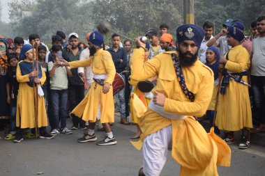 Delhi, Hindistan, 17 Kasım 2024 - Doğu Delhi bölgesinde Guru Nanak Dev, Nagar Kirtan 'ın doğum günü dolayısıyla geleneksel Nagar Kirtan, geleneksel Nagar geçit töreninde Sihler gatka ve dövüş sanatlarını sergiliyor