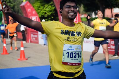 Yeni Delhi, Hindistan - 20 Ekim 2024 - Bitmek üzere olan maraton katılımcılarının bitiş çizgisini geçmek üzere olan Delhi Yarı Maratonu 2024