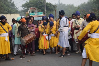 Delhi, Hindistan, 17 Kasım 2024 - Doğu Delhi bölgesinde Guru Nanak Dev, Nagar Kirtan 'ın doğum günü dolayısıyla geleneksel Nagar Kirtan, geleneksel Nagar geçit töreninde Sihler gatka ve dövüş sanatlarını sergiliyor