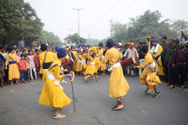 Delhi, Hindistan, 17 Kasım 2024 - Doğu Delhi bölgesinde Guru Nanak Dev, Nagar Kirtan 'ın doğum günü dolayısıyla geleneksel Nagar Kirtan, geleneksel Nagar geçit töreninde Sihler gatka ve dövüş sanatlarını sergiliyor