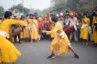 Delhi, Hindistan, 17 Kasım 2024 - Doğu Delhi bölgesinde Guru Nanak Dev, Nagar Kirtan 'ın doğum günü dolayısıyla geleneksel Nagar Kirtan, geleneksel Nagar geçit töreninde Sihler gatka ve dövüş sanatlarını sergiliyor