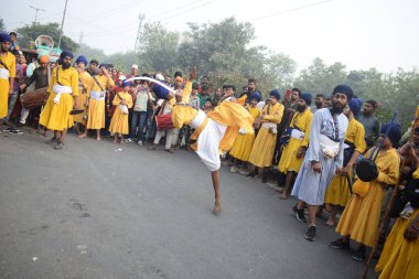 Delhi, Hindistan, 17 Kasım 2024 - Doğu Delhi bölgesinde Guru Nanak Dev, Nagar Kirtan 'ın doğum günü dolayısıyla geleneksel Nagar Kirtan, geleneksel Nagar geçit töreninde Sihler gatka ve dövüş sanatlarını sergiliyor
