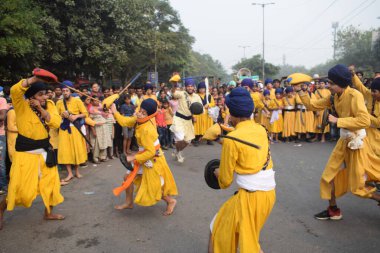 Delhi, Hindistan, 17 Kasım 2024 - Doğu Delhi bölgesinde Guru Nanak Dev, Nagar Kirtan 'ın doğum günü dolayısıyla geleneksel Nagar Kirtan, geleneksel Nagar geçit töreninde Sihler gatka ve dövüş sanatlarını sergiliyor