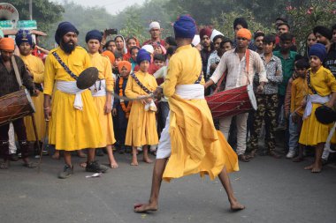 Delhi, Hindistan, 17 Kasım 2024 - Doğu Delhi bölgesinde Guru Nanak Dev, Nagar Kirtan 'ın doğum günü dolayısıyla geleneksel Nagar Kirtan, geleneksel Nagar geçit töreninde Sihler gatka ve dövüş sanatlarını sergiliyor