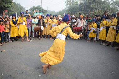 Delhi, Hindistan, 17 Kasım 2024 - Doğu Delhi bölgesinde Guru Nanak Dev, Nagar Kirtan 'ın doğum günü dolayısıyla geleneksel Nagar Kirtan, geleneksel Nagar geçit töreninde Sihler gatka ve dövüş sanatlarını sergiliyor