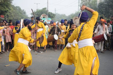 Delhi, Hindistan, 17 Kasım 2024 - Doğu Delhi bölgesinde Guru Nanak Dev, Nagar Kirtan 'ın doğum günü dolayısıyla geleneksel Nagar Kirtan, geleneksel Nagar geçit töreninde Sihler gatka ve dövüş sanatlarını sergiliyor