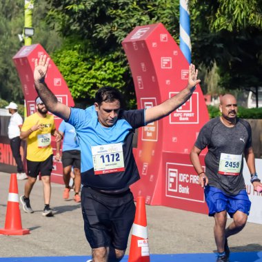 Yeni Delhi, Hindistan - 20 Ekim 2024 - Bitmek üzere olan maraton katılımcılarının bitiş çizgisini geçmek üzere olan Delhi Yarı Maratonu 2024