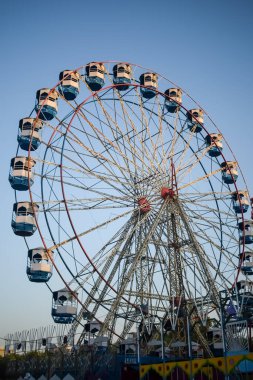 Delhi, Hindistan 'da Dussehra Mela sırasında çok renkli Dev Tekerlek' in yakın çekimi. Dev tekerlek salıncağının alt görüntüsü. Akşam vakti renkli kamaraları olan dönme dolap..