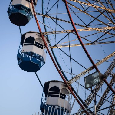 Delhi, Hindistan 'da Dussehra Mela sırasında çok renkli Dev Tekerlek' in yakın çekimi. Dev tekerlek salıncağının alt görüntüsü. Akşam vakti renkli kamaraları olan dönme dolap..