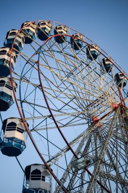 Delhi, Hindistan 'da Dussehra Mela sırasında çok renkli Dev Tekerlek' in yakın çekimi. Dev tekerlek salıncağının alt görüntüsü. Akşam vakti renkli kamaraları olan dönme dolap..