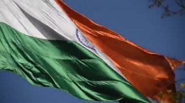 India flag flying high at Connaught Place with pride in blue sky, India flag fluttering, Indian Flag on Independence Day and Republic Day of India, tilt up shot, Waving Indian flag, Har Ghar Tiranga